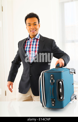 Mixed Race businessman carrying suitcase Banque D'Images