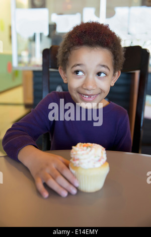 Mixed Race girl en cupcake bakery Banque D'Images