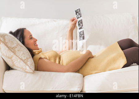 Pregnant Hispanic woman admiring photos d'échographie Banque D'Images