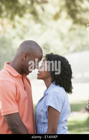 Couple rubbing noses in park Banque D'Images