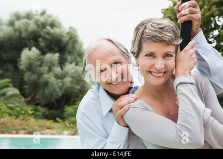 Couple standing by swimming pool Banque D'Images