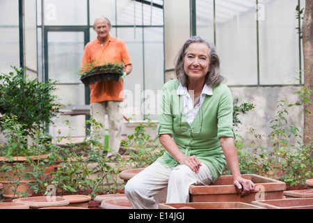 Couple potting plants in greenhouse Banque D'Images