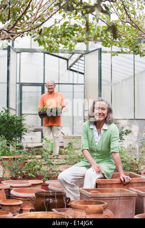 Couple potting plants in greenhouse Banque D'Images