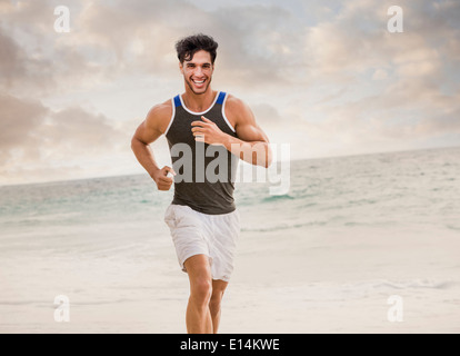 Caucasian man running on beach Banque D'Images