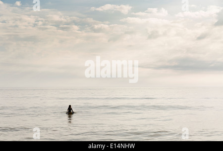 Surfer hispaniques floating in water Banque D'Images