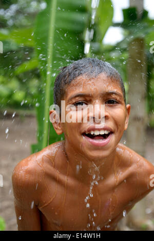 Garçon brésilien tenait la tête dans un flux d'eau et de rire, projet social pour les enfants des rues, Maranguape, Ceará, Brésil Banque D'Images