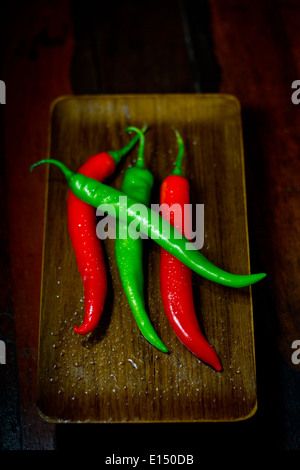 Frais [quatre 4 gousses rouge profond vert][Piment corne de chèvre][Le poivre de Cayenne] sur bois laque laïcs bac mis [en haut] Banque D'Images