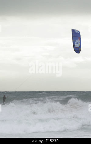 Seul un kite surfer jouit de conditions difficiles dans la bouche de l'enfer Bay, au nord du Pays de Galles Banque D'Images