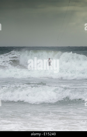 Seul un kite surfer jouit de conditions difficiles dans la bouche de l'enfer Bay, au nord du Pays de Galles Banque D'Images