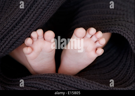 Bébé nouveau-né pieds sur couverture souple brun Banque D'Images