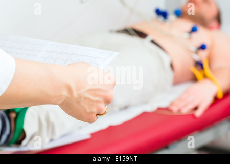 Femme médecin l'analyse de l'électrocardiogramme ECG patient in hospital Banque D'Images