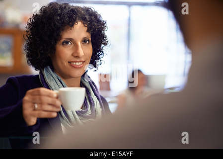 Les gens dans une cafétéria avec woman drinking espresso et holding cup Banque D'Images