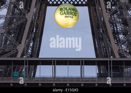 La Tour Eiffel au coucher du soleil avec un géant, balle de tennis illuminé qui pèsent sur la première plate-forme pour promouvoir l'Open de France 2014. Banque D'Images