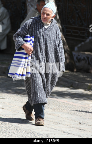 Marocaine homme portant une djellaba balade dans la ville de Chefchaouen, Maroc Banque D'Images