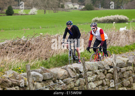 Deux cyclistes équitation dans une ruelle près de Timble, North Yorkshire UK Banque D'Images