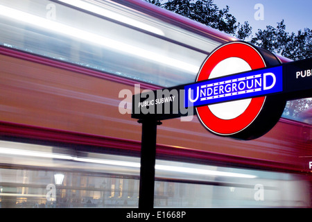 Trafalgar Square Tube métro station de métro cocarde rouge signe avec London bus passant sur route derrière London England UK Banque D'Images