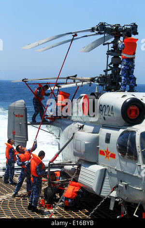 Mer de Chine orientale. 24 mai, 2014. Des soldats de la Marine chinoise travailler sur un hélicoptère avant de l'envoyer dans le hangar du destroyer lance-missiles Qingdao en Chine au cours de l'exercice naval conjoint sino-russe sur la mer de Chine orientale, le 24 mai 2014. L 'exercice de trois jours de mer commune-2014' s'est achevée avec succès le samedi. Les marines chinoise et russe ont organisé des exercices, y compris des exercices d'escorte, et l'exercice d'identification d'aéronef mixte de défense aérienne et maritime des exercices d'agression. Credit : Zha Chunming/Xinhua/Alamy Live News Banque D'Images