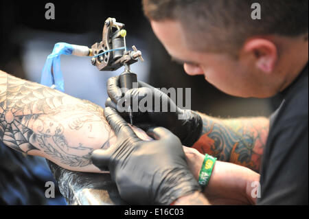 Alexandra Palace, Londres, Royaume-Uni. 24 mai 2014. Un tattoist se concentre sur son travail à la Great British Tattoo Show qui aura lieu ce week-end à l'Alexandra Palace. Le spectacle présente le tatouage, bloquer la vente de vêtements et accessoires, de lutte et d'un défilé de crédit : Matthieu Chattle/Alamy Live News Banque D'Images