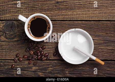 Le café, le cendrier et allume sur fond de bois vintage. Vue d'en haut Banque D'Images