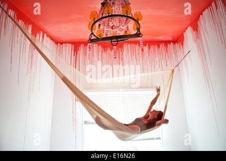 Mid adult woman lying in hammock Banque D'Images