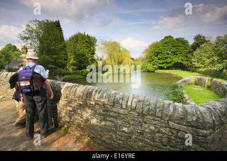 Les marcheurs pause pour étudier une carte sur le pont médiéval sur la rivière Wye Ashford au-dans-l-eau, Peak District, England, UK - mai Banque D'Images