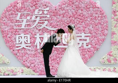 Shanghai, Chine, la province de Shandong. 25 mai, 2014. 10 Yushan Wu (R), la double championne de taekwondo de 49kg, est embrassé par l'époux Hou Kun durant leur mariage à Shanghai, la Chine de l'est la province de Shandong, le 25 mai, 2014. © Zhang Chi/Xinhua/Alamy Live News Banque D'Images