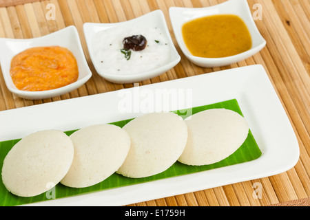 Le petit déjeuner traditionnel de l'Inde du sud sans rien faire (IDLI) servi avec des condiments (Chutney de tomates chutney de noix de coco, et des cochons) sur une plaque Banque D'Images