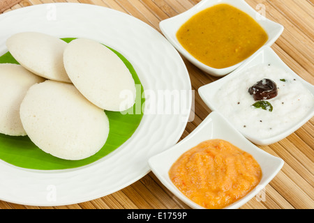 Le petit déjeuner traditionnel de l'Inde du sud sans rien faire (IDLI) servi avec Chutney de tomates chutney de noix de coco, et des cochons sur une assiette. Banque D'Images