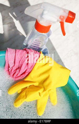 Ensemble lave-glace - gant en caoutchouc, wet duster, spray nettoyant verre bouteille, l'eau du bassin de l'eau savonneuse on windowsill Banque D'Images