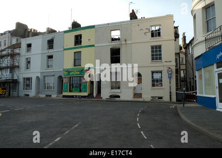 Hastings Marine Parade, les pompiers examiner grillee coquille de terrasse de maisons détruit par le feu le 25 mai 2014 Banque D'Images