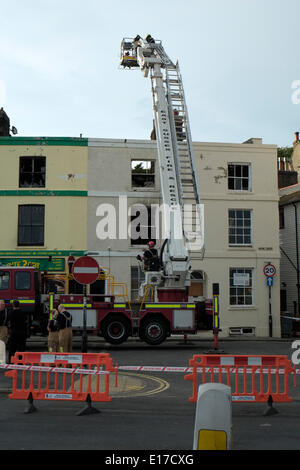 Hastings Marine Parade, les pompiers examiner grillee coquille de terrasse de maisons détruit par le feu le 25 mai 2014 Banque D'Images