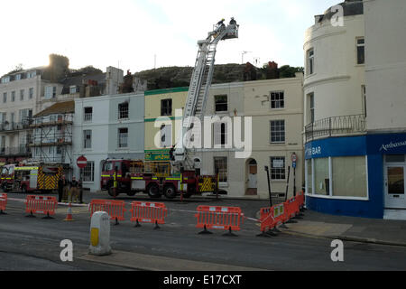 Hastings Marine Parade, les pompiers examiner grillee coquille de terrasse de maisons détruit par le feu le 25 mai 2014 Banque D'Images