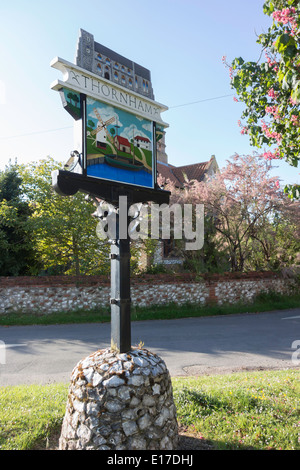 Une enseigne peinte pour le village de Thornham Norfolk UK, montrant un le port local et le moulin au printemps avec tree blossom Banque D'Images