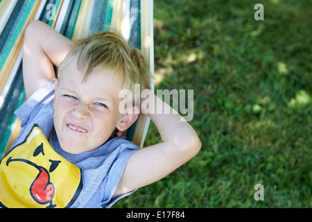 Jeune enfant garçon blond se reposant dans un hamac l'heure d'été Banque D'Images