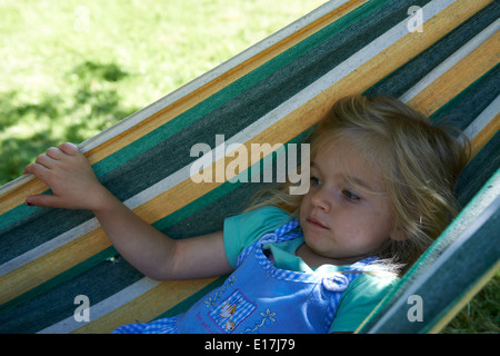 Portrait de petit enfant fille blonde dans un hamac, cour, jardin de l'été Banque D'Images