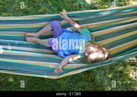 Portrait de petit enfant fille blonde dans un hamac, cour, jardin de l'été Banque D'Images