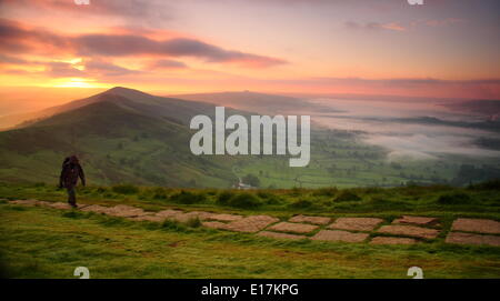 Un marcheur monte le grand Ridge sur Mam Tor au-dessus de la vallée de l'espoir près de Castleton au lever du soleil, Peak District, Derbyshire, Royaume-Uni Banque D'Images