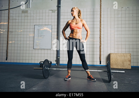 Full Length portrait of muscular young woman at gym à la voiture avec des barres au sol. Crossfit Forte femme au sport. Banque D'Images