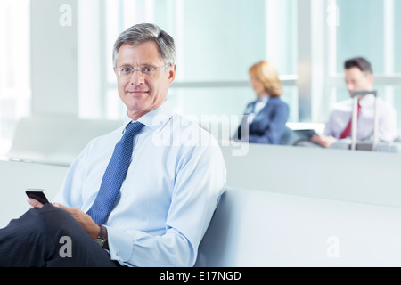 Portrait of businessman texting at airport Banque D'Images