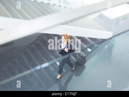 Businesswoman pulling suitcase in lobby Banque D'Images