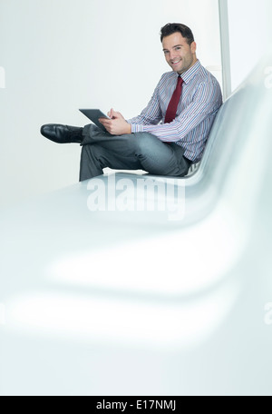 Businessman using digital tablet in lobby Banque D'Images