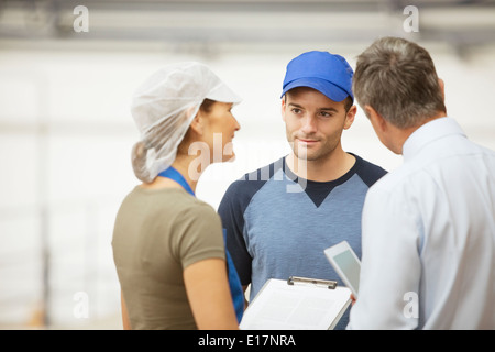Superviseur et parler des travailleurs en usine de transformation alimentaire Banque D'Images