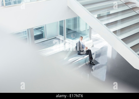 Businessman sitting in hall moderne Banque D'Images