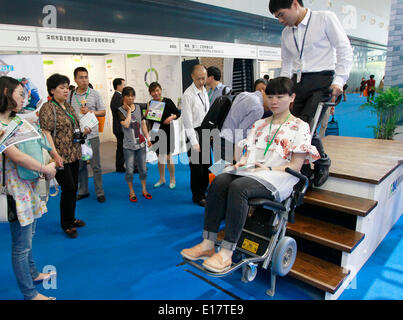 Shanghai, Chine. 26 mai, 2014. Un visiteur essaye un fauteuil roulant capable de monter des escaliers à la 9e Salon International des soins aux personnes âgées, médecine de réadaptation et les soins de santé dans l'est de la Chine, Shanghai, 26 mai 2014. Les soins aux personnes âgées expo le coup d'ici lundi, où plus de 300 entreprises dans le monde ont montré leurs produits. © Ding Ting/Xinhua/Alamy Live News Banque D'Images