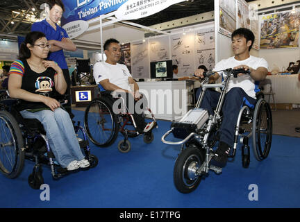 Shanghai, Chine. 26 mai, 2014. Un visiteur (R) tente un fauteuil roulant entraîné par une machine à moteur à la 9e Salon International des soins aux personnes âgées, médecine de réadaptation et les soins de santé dans l'est de la Chine, Shanghai, 26 mai 2014. Les soins aux personnes âgées expo le coup d'ici lundi, où plus de 300 entreprises dans le monde ont montré leurs produits. © Fang Zhe/Xinhua/Alamy Live News Banque D'Images