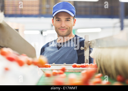 Portrait de la courroie du convoyeur au travailleur dans l'usine de transformation des aliments Banque D'Images