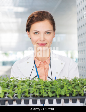 Portrait de botaniste holding tray of plant plants Banque D'Images