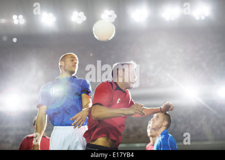 Joueurs de football de sauter sur le terrain de balle Banque D'Images