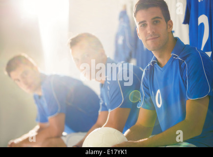 Joueurs de football assis dans le vestiaire Banque D'Images