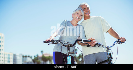 Senior couple with bicycles on beach Banque D'Images